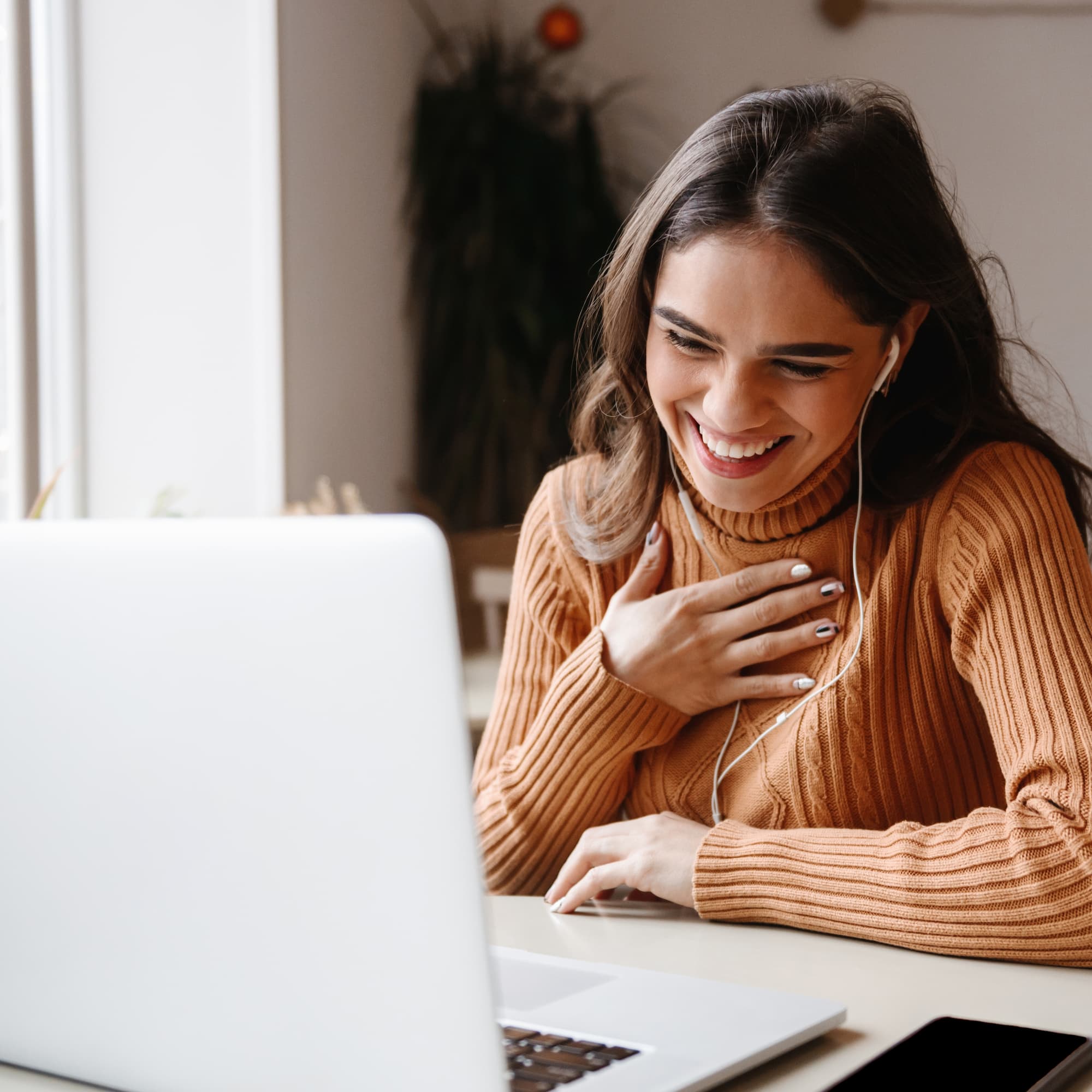 Smiling woman using telehealth on laptop. Telehealth connections, online consultation, virtual appointment.